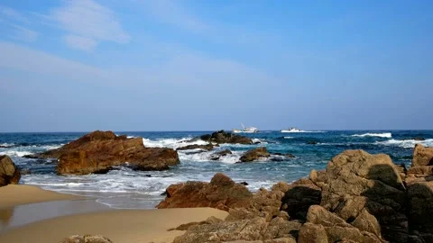 The waves of blue strike the rocks and produce white bubbles. Stock Footage 145967893