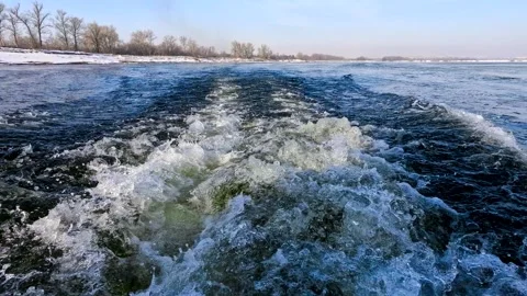 Waves from a boat sailing on a cold winter river Stock Footage 306548327