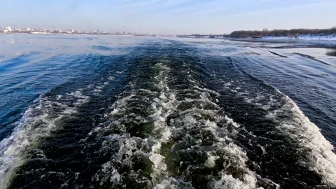 Waves from a boat sailing on a cold winter river Stock Footage 321612256