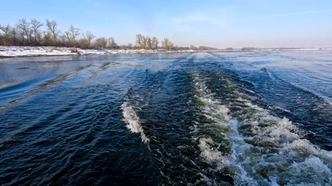 Waves from a boat sailing on a cold winter river Stock Footage 321612292
