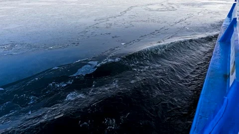 Waves from a boat sailing on a cold winter river Stock Footage 321612299