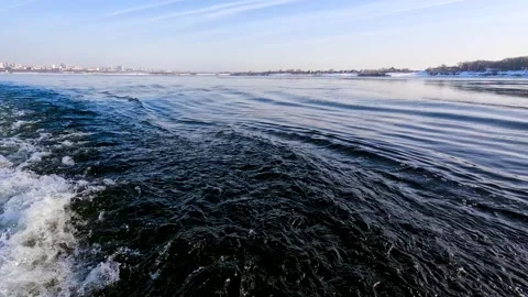 Waves from a boat sailing on a cold winter river Stock Footage 328228400