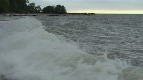 Waves break against a beach in small bay Stock Footage 132585902