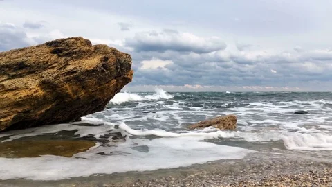 Waves break against a stone 4K Stock Footage 81737198