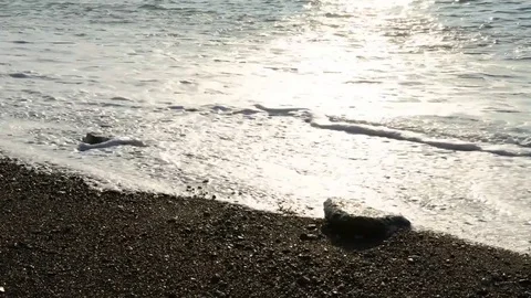 The waves break on the beach early in the day Stock Footage 84007096