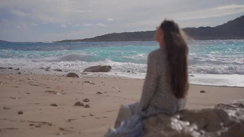 Waves break on the beach shore. A young woman out of focus Stock Footage 195211067