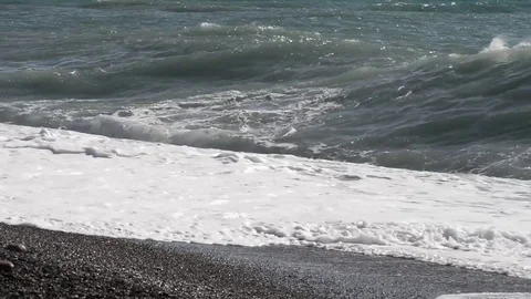 The waves break on the beach on a windy and sunny day Video stock 84025992