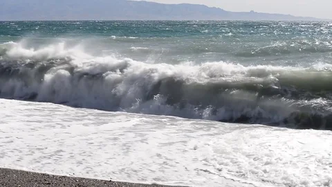 The waves break on the beach on a windy and sunny day Stock Footage 84027015