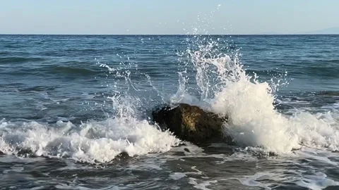 Waves break on a large stone Stock Footage 220606327