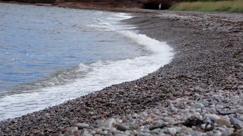 Waves break at pebble beach Video stock 79628645
