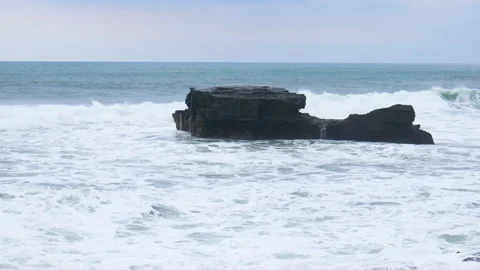 Waves break on a rock in the ocean Stock Footage 147740570