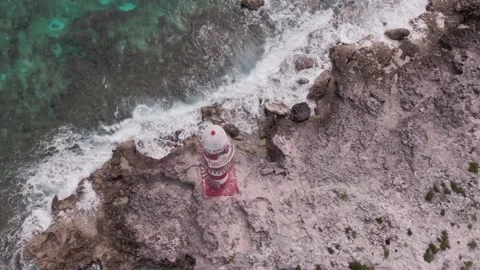 Waves break on the rock on which the lighthouse stand, aerial view Stock Footage 171635235