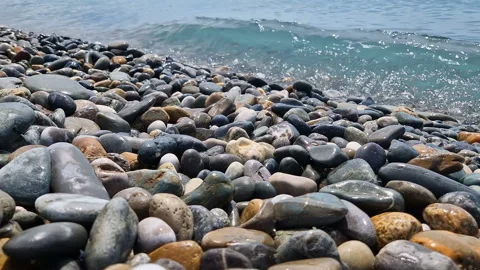 Waves break on the rocks on the beach, sea spray, sunlight is reflected in the Stock Footage 280584873