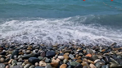 Waves break on the rocks on the beach, sea spray, sunlight is reflected in the Video stock 280587143