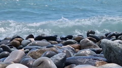 Waves break on the rocks on the beach, sea spray, sunlight is reflected in the Stock Footage 280587189