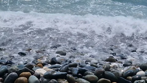 Waves break on the rocks on the beach, sea spray, sunlight is reflected in the Stock Footage 280587665