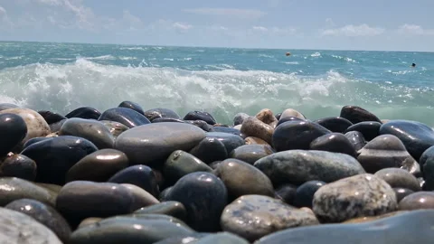 Waves break on the rocks on the beach, sea spray, sunlight is reflected in the Stock Footage 280588135