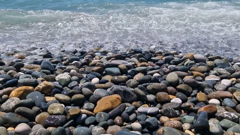 Waves break on the rocks on the beach, sea spray, sunlight is reflected in the Stock Footage 280652400