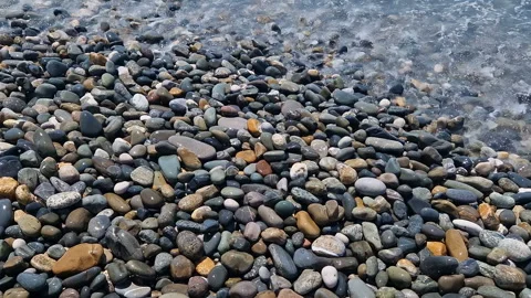 Waves break on the rocks on the beach, sea spray, sunlight is reflected in the Stock Footage 280742897