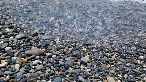 Waves break on the rocks on the beach, sea spray, sunlight is reflected in the Stock Footage 280966266