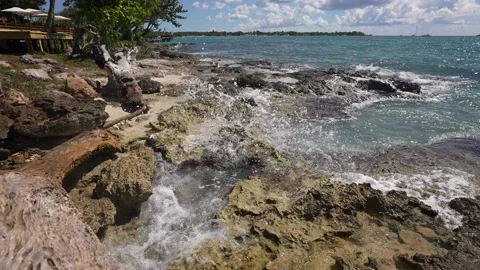 Waves break on rocks in a blue ocean. Sea waves on beautiful beach aerial view Stock Footage 165992910