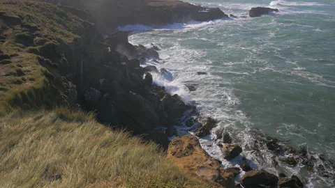 Waves break on the rocks of a cliff, in New Zealand Stock Footage 219177605