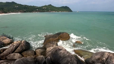 The waves break on the rocks next to the old, small marina. Stock Footage 230078780