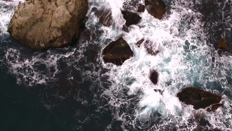 Waves break on the rocks view from the height, huge snow-white waves Stock Footage 131588314