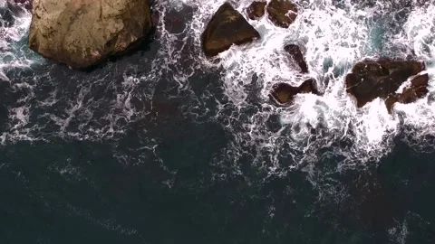 Waves break on the rocks view from the height, huge snow-white waves Stock Footage 131588386