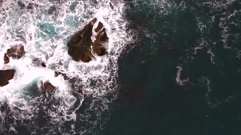 Waves break on the rocks view from the height, huge snow-white waves Stock Footage 131588404