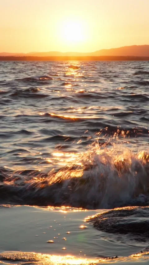 The waves break on the rocky shore. Drops of water are flying around. Stock Footage 267647352