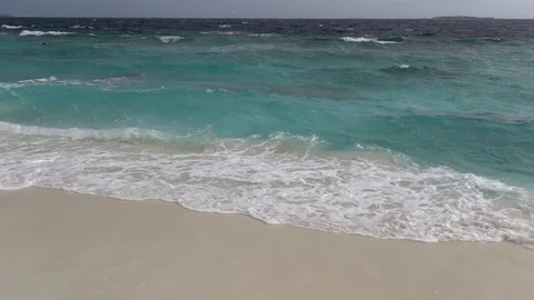 Waves break on sandy beach at stormy weather. Maldives. Slow motion Stock Footage 119175492