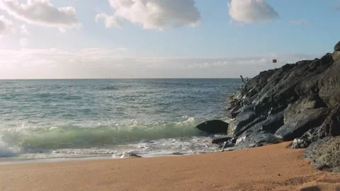 Waves break on shore and rocks, sunset, man with son jumps in ocean off rocks. Stock Footage 133827981