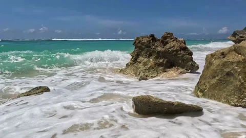 Waves break on a stone in the ocean and the spray scatters beautifully Stock Footage 227457463