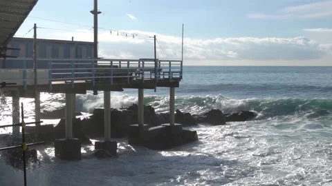 Waves break through on a pier on the Genoese coast in slow motion. Video stock 147718890