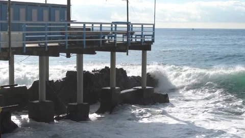 Waves break through on a pier on the Genoese coast in slow motion. Video stock 147718910