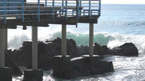 Waves break through on a pier on the Genoese coast in slow motion. Video stock 147718937