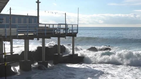 Waves break through on a pier on the Genoese coast in slow motion. Stock Footage 147718941