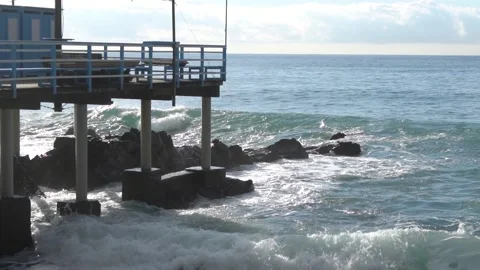 Waves break through on a pier on the Genoese coast in slow motion. Video stock 147719104