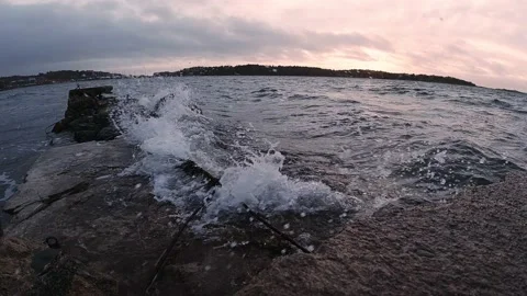 Waves breaking against a broken stone pier at sunset Stock Footage 145870864