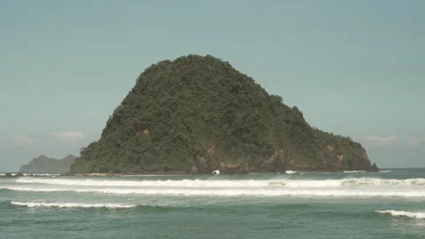 Waves Breaking Against Green Island at Red Island Beach, Banyuwangi, Indonesia Stock Footage 336009680