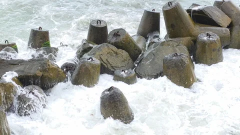 Waves breaking against robust concrete tetrapods, creating splashes and foam 스톡 동영상 336181997