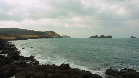 Waves breaking against the rocks in a cloudy day at the beach. Stock Footage 116580814
