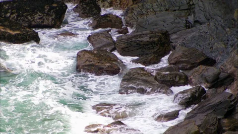 Waves breaking against rocks Video stock 95604811