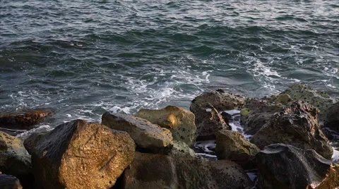 Waves breaking against rocks on sea shoreline. Stock Footage 68025652