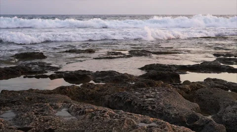 Waves breaking against rocks on sea shoreline. Stock Footage 68030423
