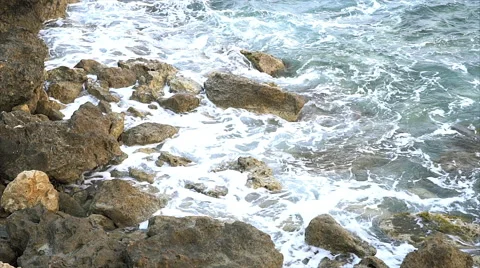 Waves breaking against rocks on sea shoreline. 스톡 동영상 68032156