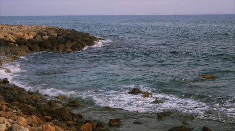 Waves breaking against rocks on sea shoreline. Stock Footage 68038379