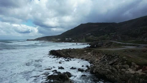 Waves breaking against a rocky headland, aerial view, Crete Stock Footage 346723934