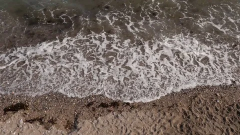 Waves breaking against the sand, birds eye view 스톡 동영상 74603906
